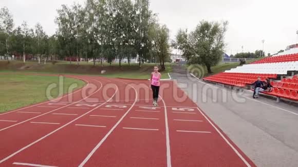 女孩绕着体育场跑视频的预览图