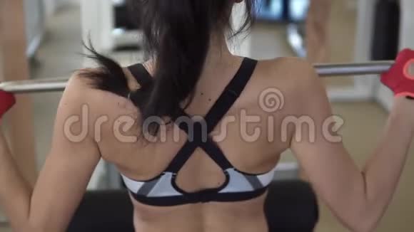 后面的女孩特写运动员在背部肌肉上做运动背面视图视频的预览图