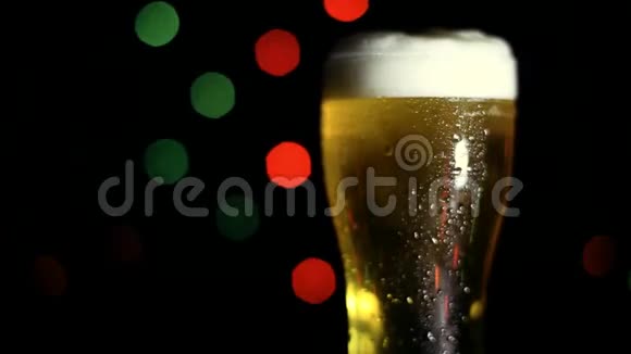 黑色背景上的一杯冷啤酒有彩灯高清高清视频的预览图