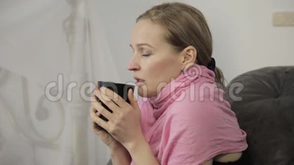 生病的女人大声打喷嚏擦鼻涕喝热茶视频的预览图