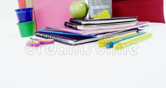 笔架上的彩色铅笔有一堆书苹果和文具视频的预览图