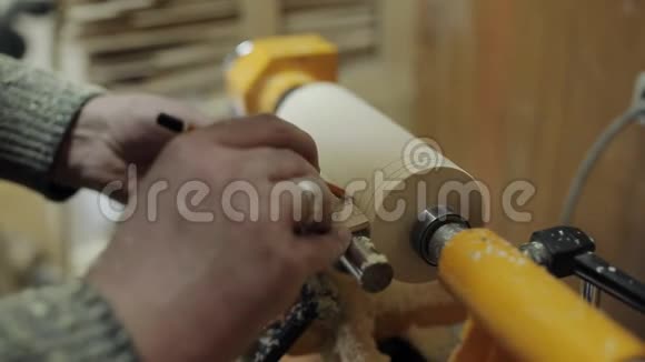 木工在一个木工车间的机器上磨出木块优雅的支架视频的预览图