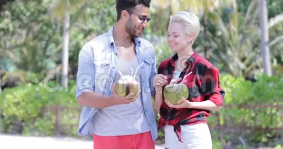 情侣饮料椰子鸡尾酒会在棕榈树上交谈快乐男人和女人微笑游客交流视频的预览图