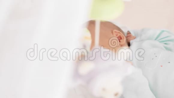 熟睡的新生婴儿和旋转婴儿床视频的预览图