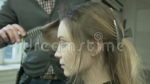 专业理发师用吹风机带有吹风机的男式设计师年轻女子把头发梳成一头视频的预览图