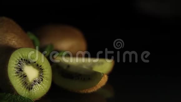 美味多汁的水果猕猴桃和薄荷放在黑桌上从桌子上反射猕猴桃高清视频的预览图