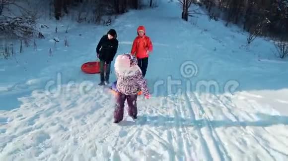 一个年轻的女人带着她十几岁的儿子和女儿爬上山滑旱冰视频的预览图
