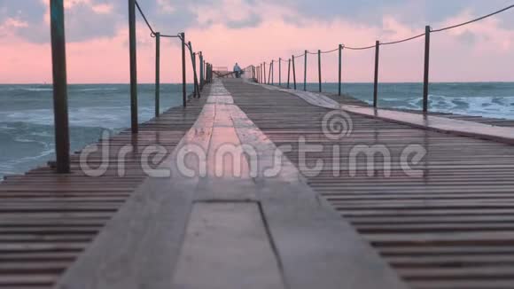 美丽的海景与粉红色日落码头和风暴波在晚上视频的预览图