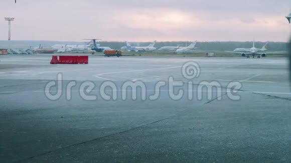 机场的飞机在乘客大门前橙色的汽车在周围移动视频的预览图