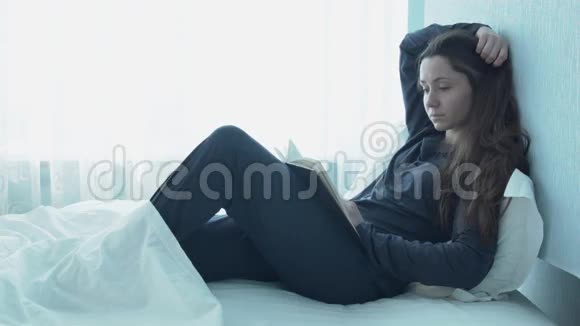 年轻漂亮的女人在床上看书聪明的女孩是自己从事教育的视频的预览图