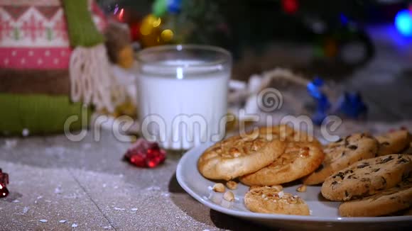木制棕色桌子上面装饰着圣诞用品和花环女人手把饼干放在盘子里视频的预览图