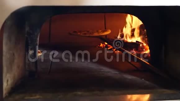 披萨是在传统的木材燃烧比萨饼面包餐厅烤箱烘烤厨师比萨饼师烹饪比萨饼餐厅视频的预览图