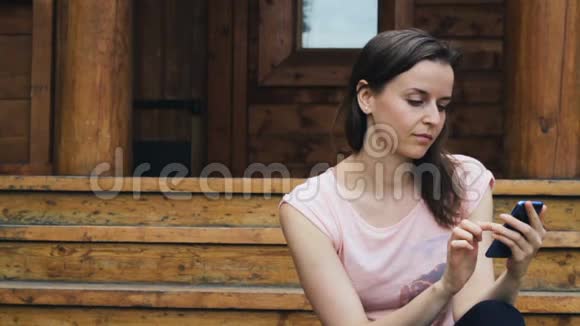 一个漂亮女孩在户外查看手机信息视频的预览图