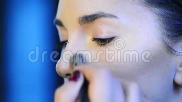 化妆师将skintone粉底应用于模特漂亮的脸上视频的预览图