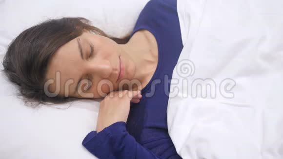 晚上睡在床上的西班牙女人的俯视图视频的预览图