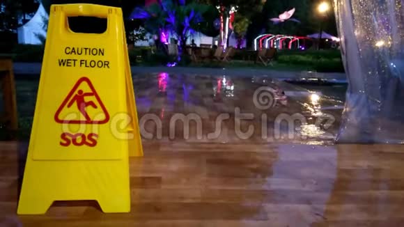 没有声音镜头站在黄色警告湿标志而雨天视频的预览图