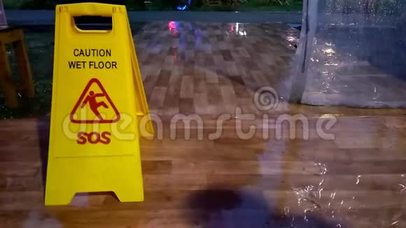 没有声音镜头站在黄色警告湿标志而雨天视频的预览图