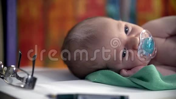 婴儿用张开的眼睛缓慢地吸吮奶嘴视频的预览图