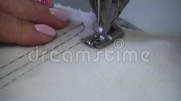 中年妇女手工缝制米色织物缝纫机视频的预览图