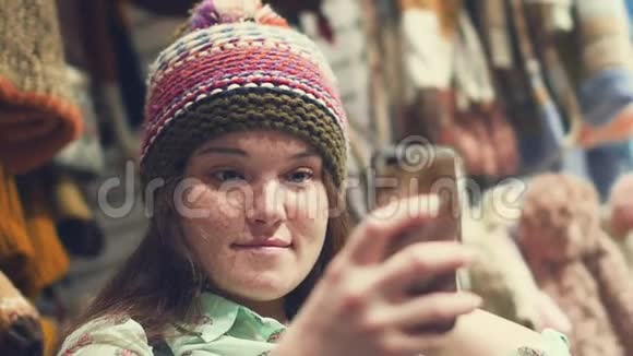 一个微笑的黑发女人的肖像在商店里戴着一顶冬帽视频的预览图
