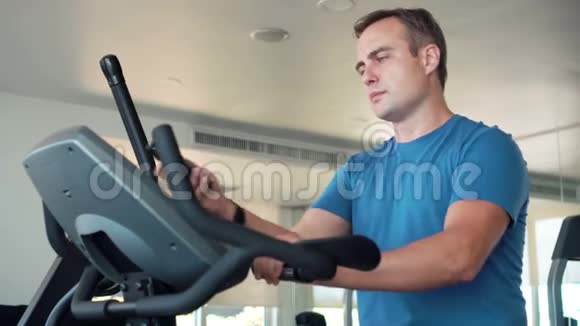 帅哥适合在健身房做运动的年轻人使用智能手机和朋友vieSkype通话视频的预览图