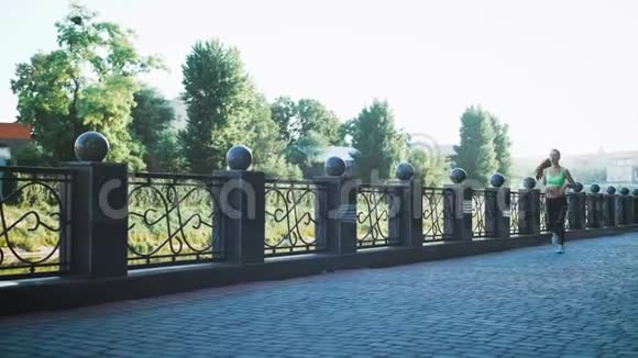 活跃的妇女在城市人行天桥上慢跑视频的预览图