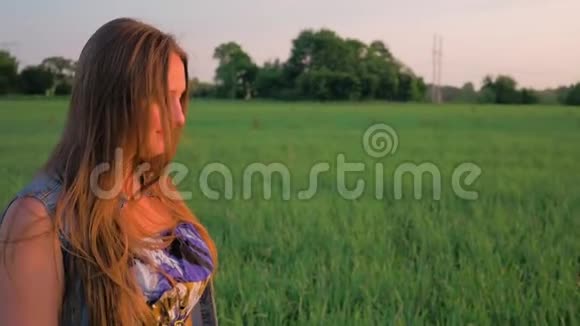 日落时分一位美丽的年轻女子站在绿色的田野上在大自然中微笑和放松带着呼吸视频的预览图
