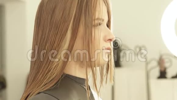在美发沙龙理发时面对湿发的年轻女子关闭美容工作室的女性美发视频的预览图
