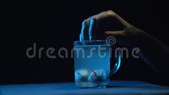 僵尸手从装有液体的玻璃烧杯中取出眼睛视频的预览图