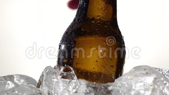 人手从冰上拿啤酒白色背景快关门慢动作视频的预览图