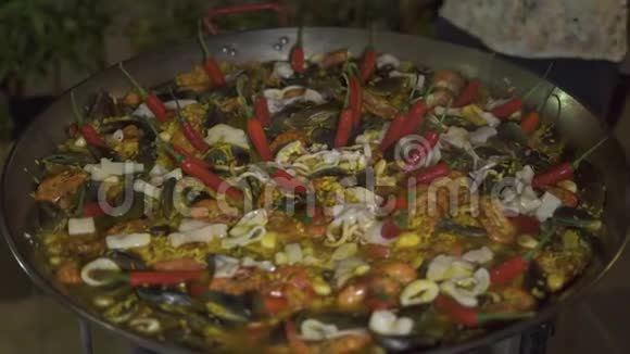 用红辣椒和新鲜海鲜在锅里煮西班牙海鲜饭西班牙传统食品海鲜饭视频的预览图