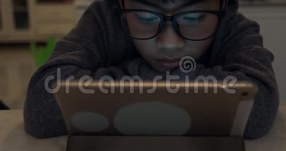 把戴眼镜和使用平板电脑的可爱的亚洲男孩关起来视频的预览图