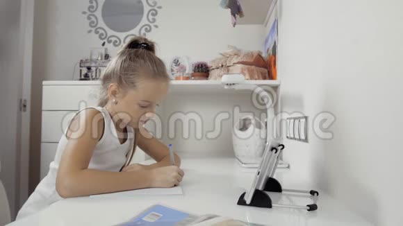 那个女孩写书教训的决定在家里和平板电脑一起工作做作业视频的预览图