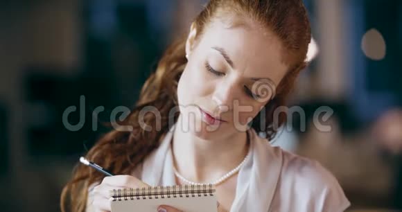 红头发的女人写着记事本的肖像企业业务团队工作办公会议高加索商人和视频的预览图