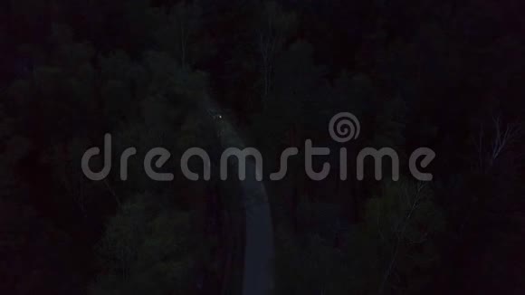 夜间在夏林之间的黑暗乡村道路上行驶的空中观景车视频的预览图