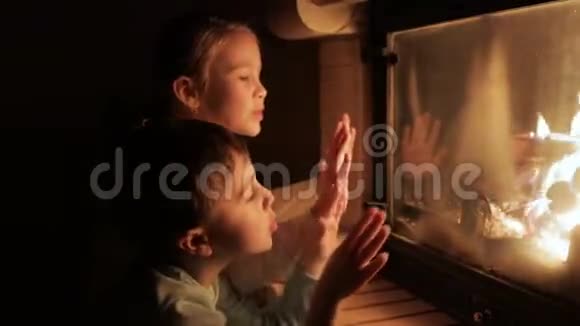 两个快乐的小孩坐在壁炉旁视频的预览图