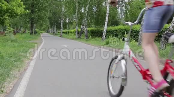 孩子们在公园里骑自行车和滑板车视频的预览图