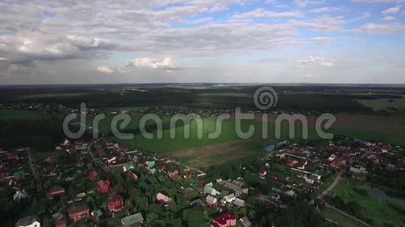 在绿色的田野和森林中飞过俄罗斯的村庄视频的预览图