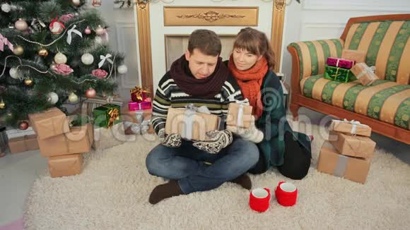 一对年轻夫妇为观众送礼物给相机圣诞节和新年主题视频的预览图