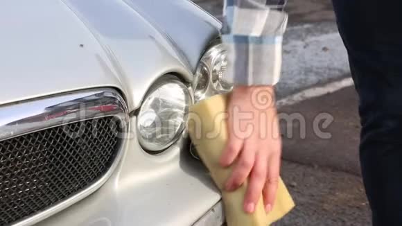 这个人用海绵仔细地清洗他最喜欢的汽车洗车自助服务视频的预览图