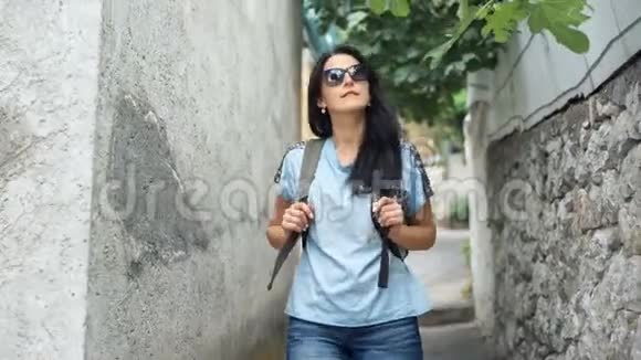 夏天一位背着背包的年轻女子在欧洲老城散步视频的预览图