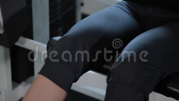 运动美女在模拟器腿部伸展上表演视频的预览图