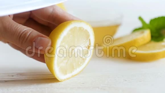 在白色木板上用刀切鲜黄柠檬的女性手的特写慢动作视频视频的预览图