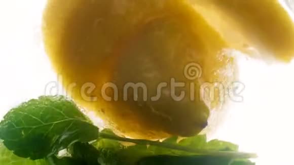 特写4k片柠檬片和薄荷叶漂浮在新鲜冷柠檬水中视频的预览图