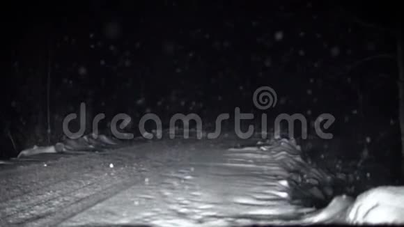 汽车在夜间沿着雪道行驶视频的预览图