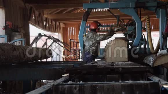 戴着安全帽的木工切割工业锯工作台上的木材视频的预览图