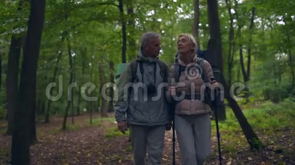 在森林里沿着小路走着的老夫妇视频的预览图