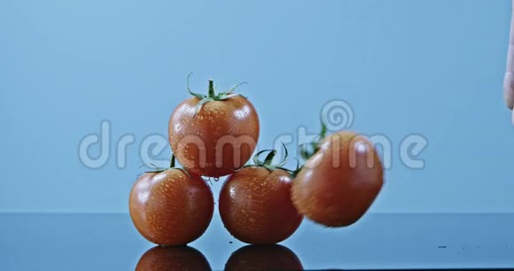 三个成熟的西红柿在光滑的表面上一个人扔了一个西红柿慢动作2k视频推240fps视频的预览图