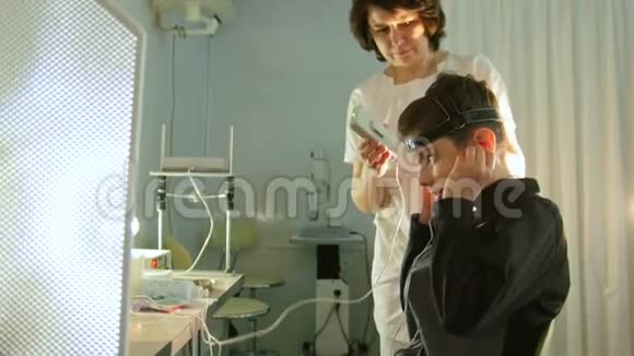 健康儿童诊断验光师为男孩病人安装脑眼设备眼科诊所视频的预览图