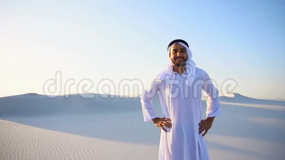 在阳光明媚的无底沙漠中的坎杜拉美丽的穆斯林人阿拉伯阿联酋酋长的慢镜头肖像视频的预览图